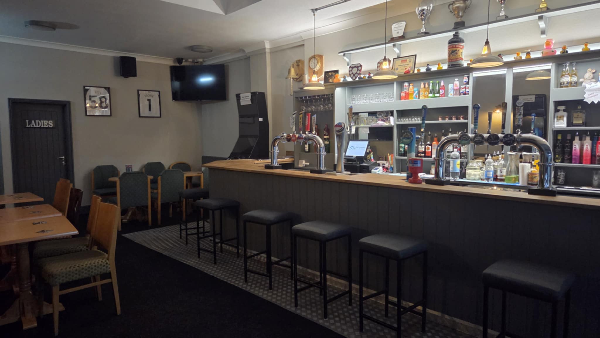 Bar taps at Wisbech EX Services with dartboards visible